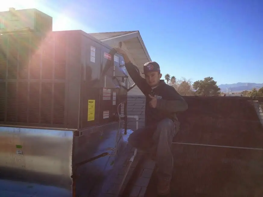 HVAC technician performing Air Duct Cleaning on a rooftop unit in Osage Beach